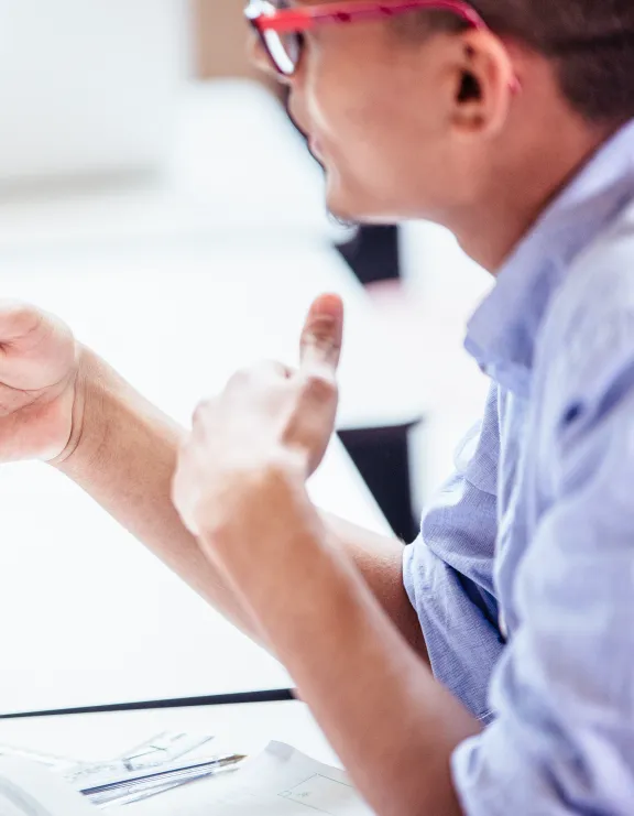 Mann mit Stift in der Hand erklärt etwas eine Frau